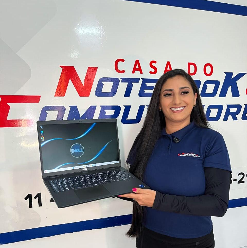 Cliente satisfeito segurando notebook consertado na assistência técnica